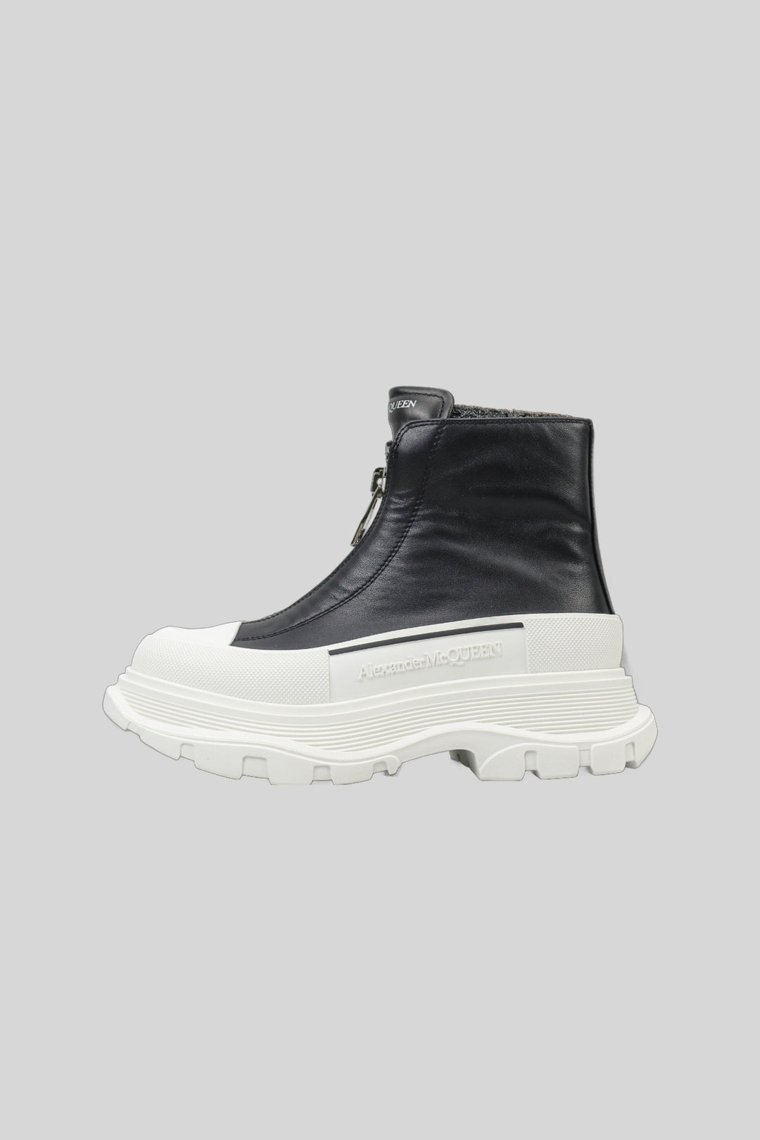 Bota Tread Slick com zíper preto e branco - Alexander McQueen — produto em fundo cinza-claro uniforme
